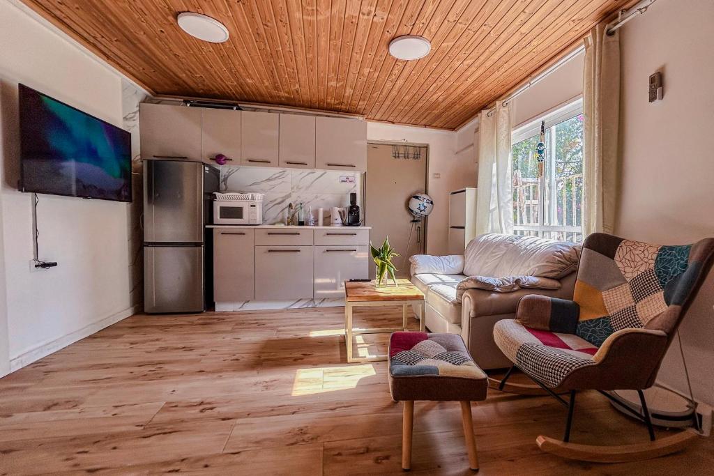 a living room with a couch and a kitchen at Bright 2 Bedroom, Private Garden in Herzliya