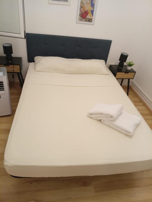 a bed with two white towels on top of it at Stylish Apartment in Downtown Budapest in Pusztavacs