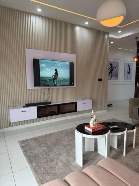 a living room with a tv on a wall at 2bedroom Harmony Apartment in Abuja