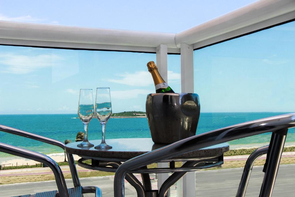 a table with a bottle of wine and two glasses at Hotel Santorini in Vila Velha