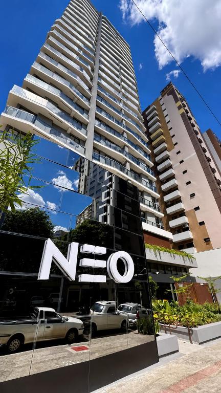 a tall building with a sign in front of it at Neo House in Maringá