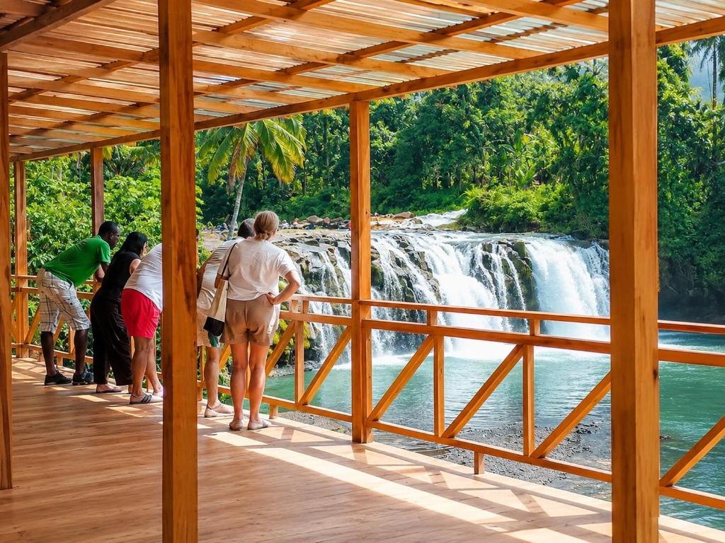 a group of people standing in front of a waterfall at Cascata- Pousada Encanto Do Mar in Santa Irene