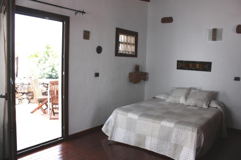 a bedroom with a bed and a door to a patio at Casa Rural "La Molina" in Máguez