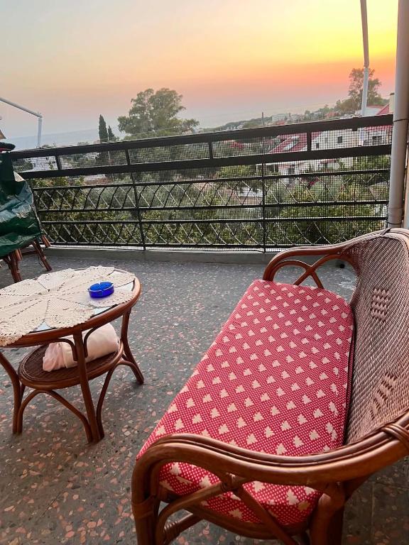 a rocking chair and a table on a balcony at Theofania House Kanali in Kanali