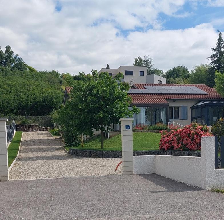 a house with a white fence and a yard at Gite des Reguinelles in Saint-Lattier