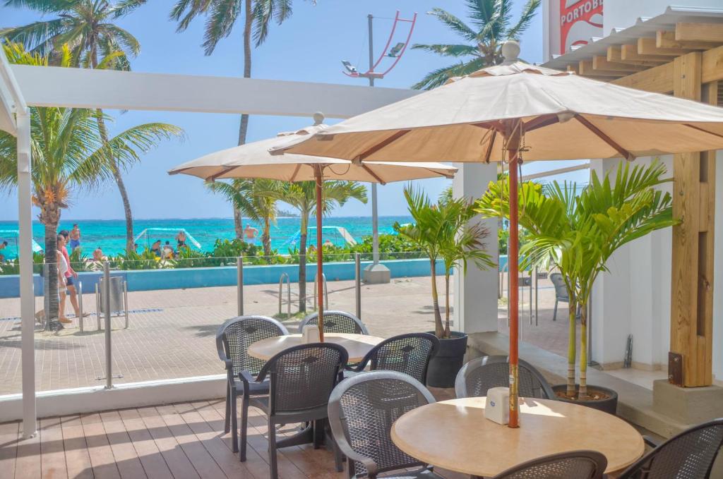 Eine Terrasse mit Tischen und Stühlen, im Hintergrund das Meer. in der Unterkunft Hotel Portobelo beach in San Andrés