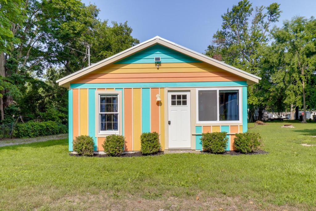 a colorful shed in a field of grass at Fire Pit, Gas Grill! Bright Cottage By Devils Lake in Manitou Beach