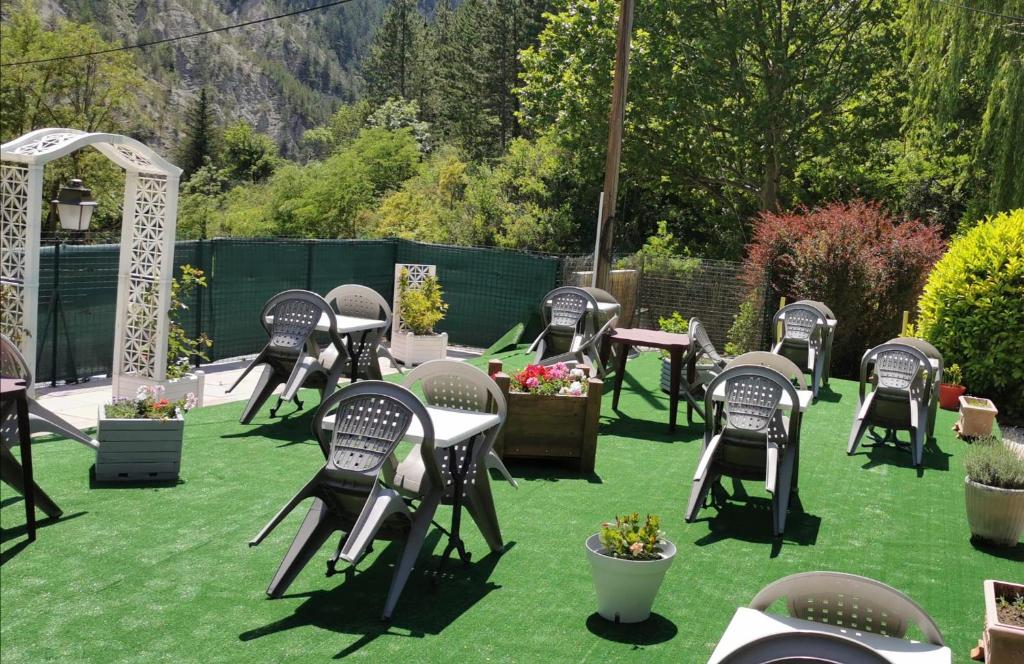 a group of chairs sitting on the grass in a garden at Auberge Du Riou in Puget-Rostang