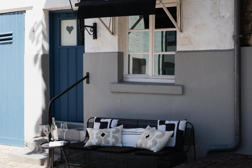 a black bench with white pillows on a patio at Onder de Linde B&B in Valkenburg