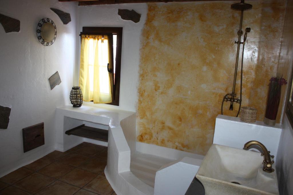 a bathroom with a tub and a sink and a bath tub at Casa Rural "La Molina" in Máguez