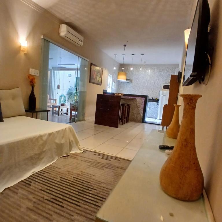 a room with a bed and a living room at Casa Aconchego! in Uberaba