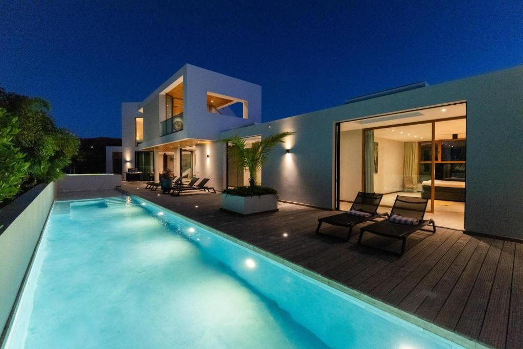 a swimming pool in front of a house at night at Long Lap Pool - Modern Villa - Jan Thiel Beach in Jan Thiel