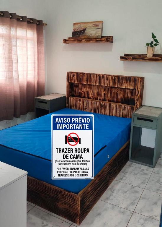 a bed in a room with a sign on it at Apartamento no Camping Mairipora in Mairiporã