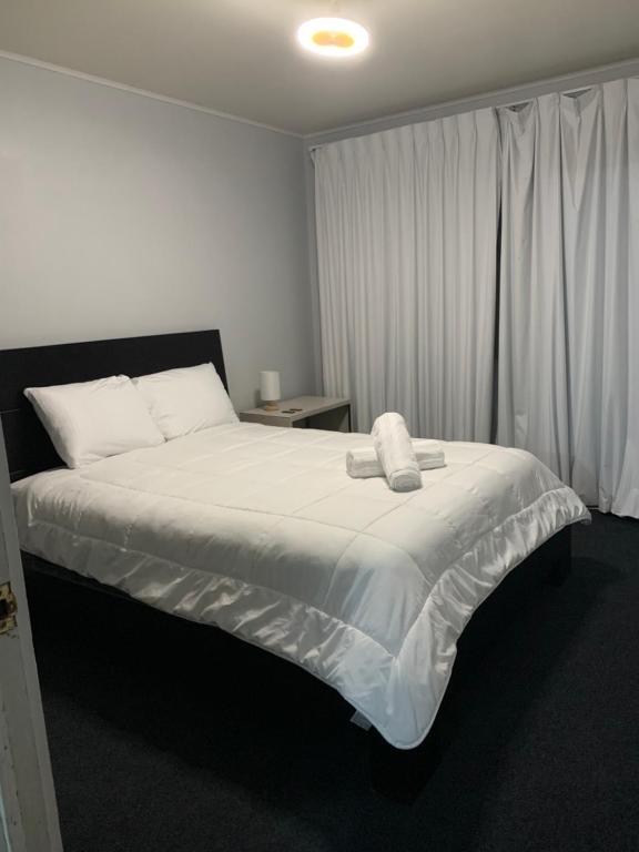 a bedroom with a large bed with white sheets at Zenora Suites in San José
