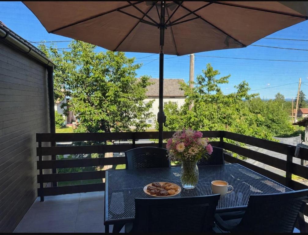 a table with a plate of food and an umbrella at House Sweet stay by Deda Ferda late self check in in Draganići