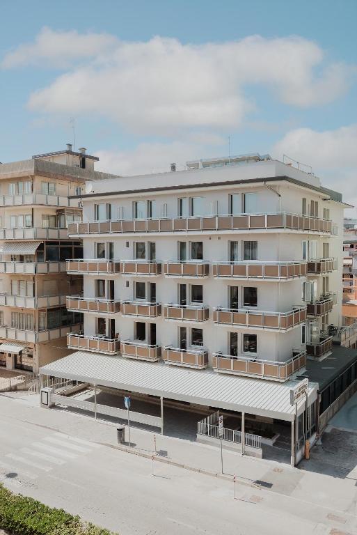 a large white building with a lot of windows at Hotel Grand Prix in Sottomarina