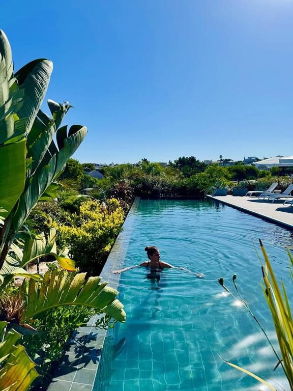 a woman swimming in a swimming pool in a resort at Anastasio Hotel & Beach Club in José Ignacio