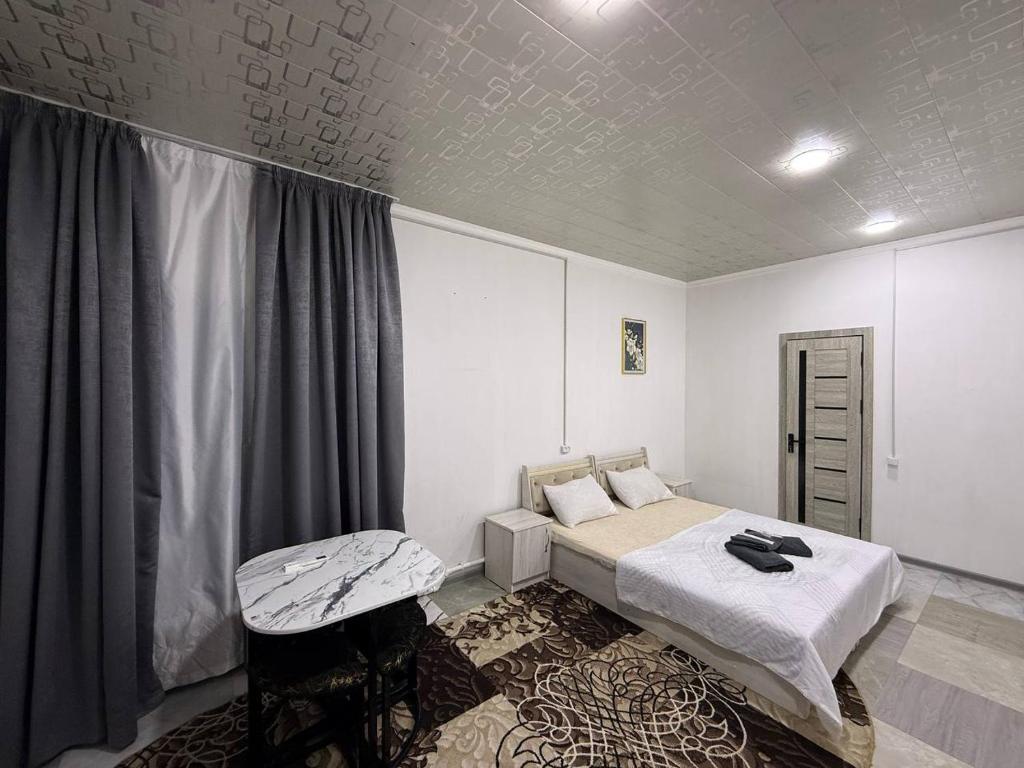 a bedroom with a bed and a chair in it at 888 отель in Yunusobod