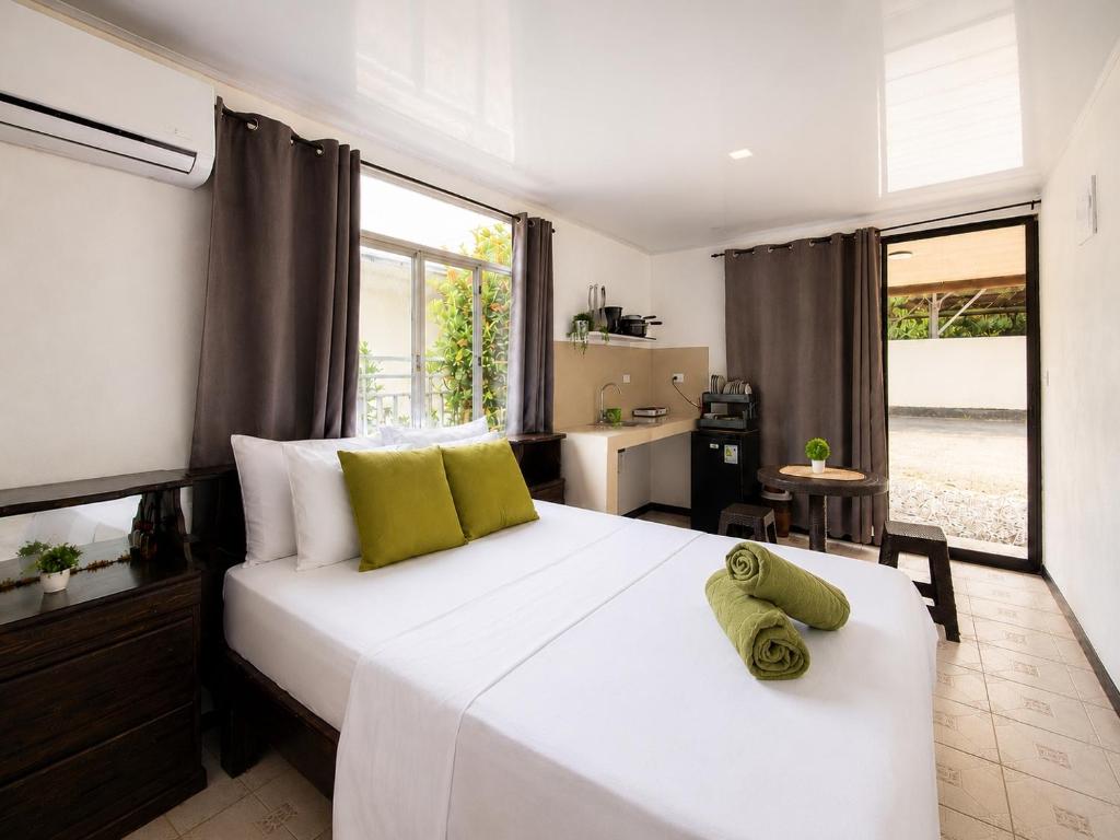 a bedroom with a large white bed with a window at Anluka Estudio Yaguarundi in Puerto Jiménez