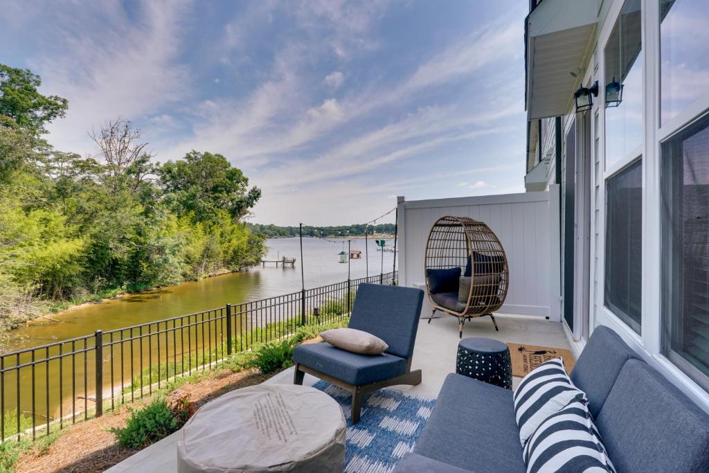 a porch with a couch and a chair and water at Dock Access! 'Hook & Heron Lakefront Getaway' in Greenwood