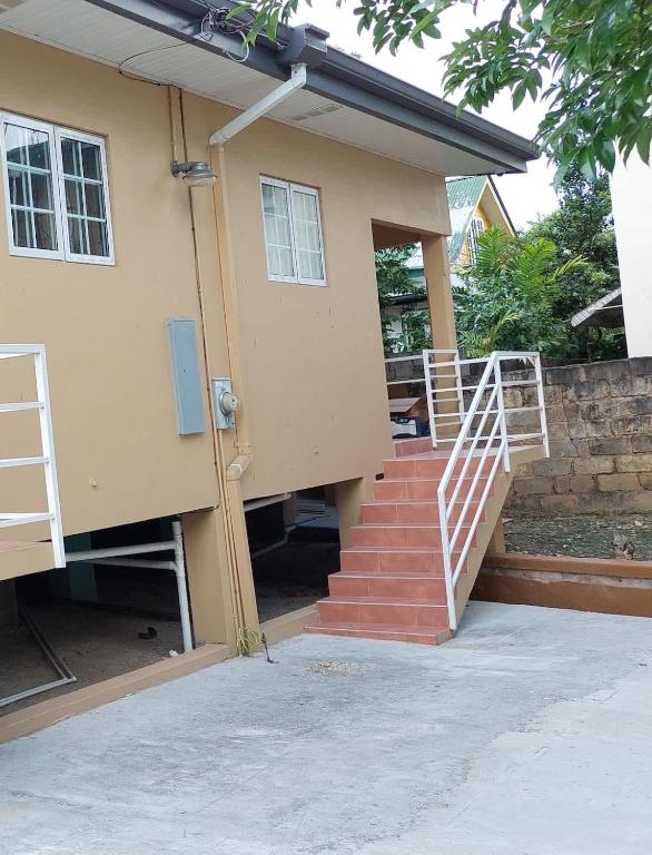 a house with a staircase leading to the door at Santa Fe in Port-of-Spain