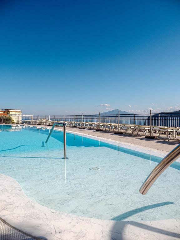 a large swimming pool with a view of the ocean at Hotel Cristina in Sorrento
