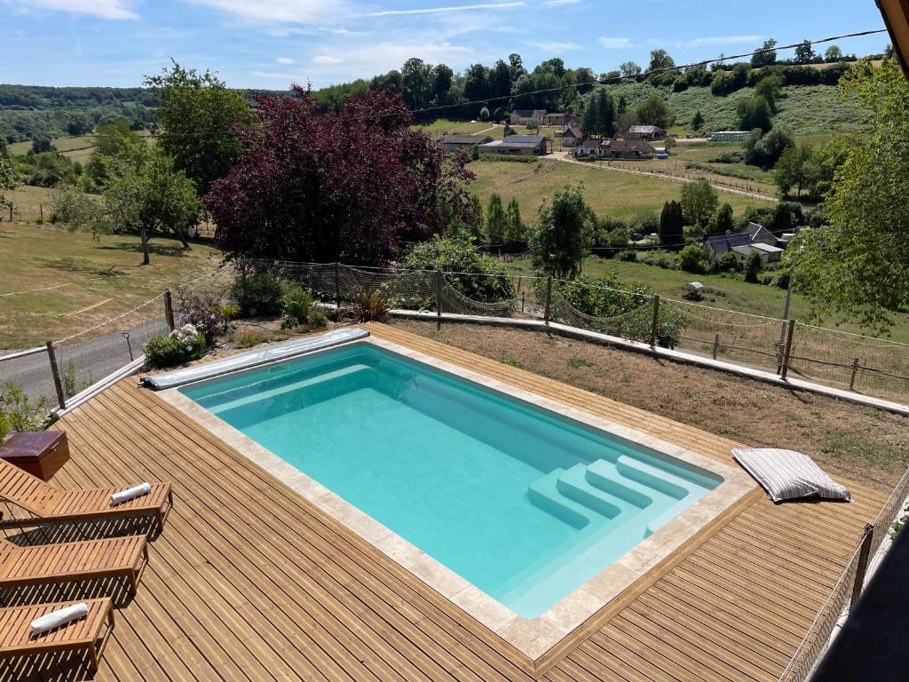 a swimming pool on top of a wooden deck at Cottage de charme avec piscine et vue panoramique - 6-8 pers Pays d'Auge in Vimoutiers