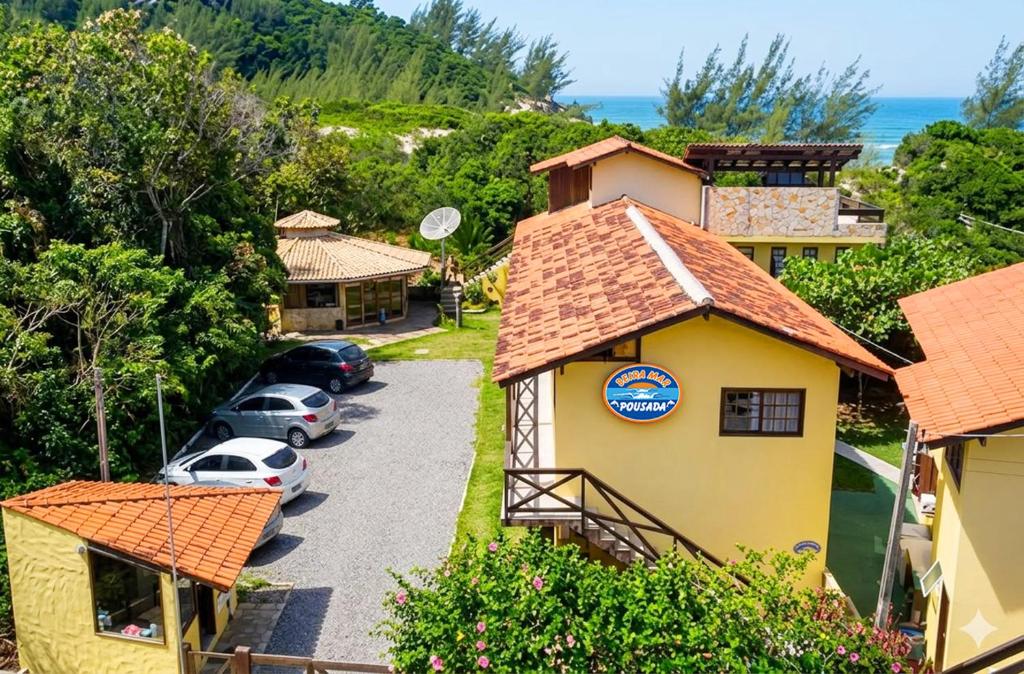 an aerial view of a house with cars parked in a driveway at Pousada Beira Mar in Garopaba