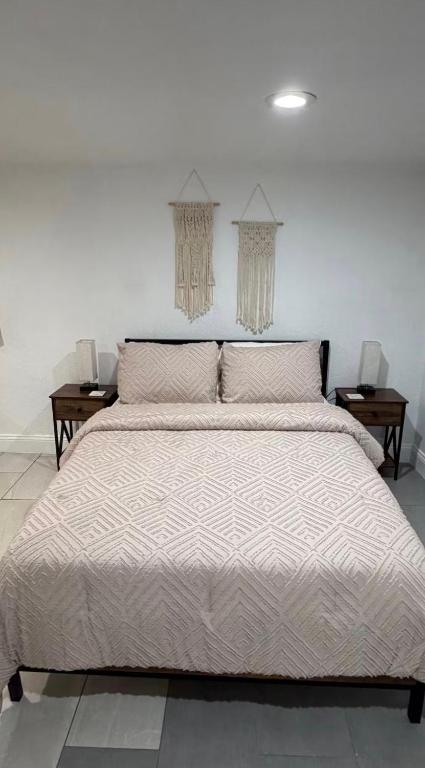 a large bed in a bedroom with two tables at Small Space Charm in Tampa