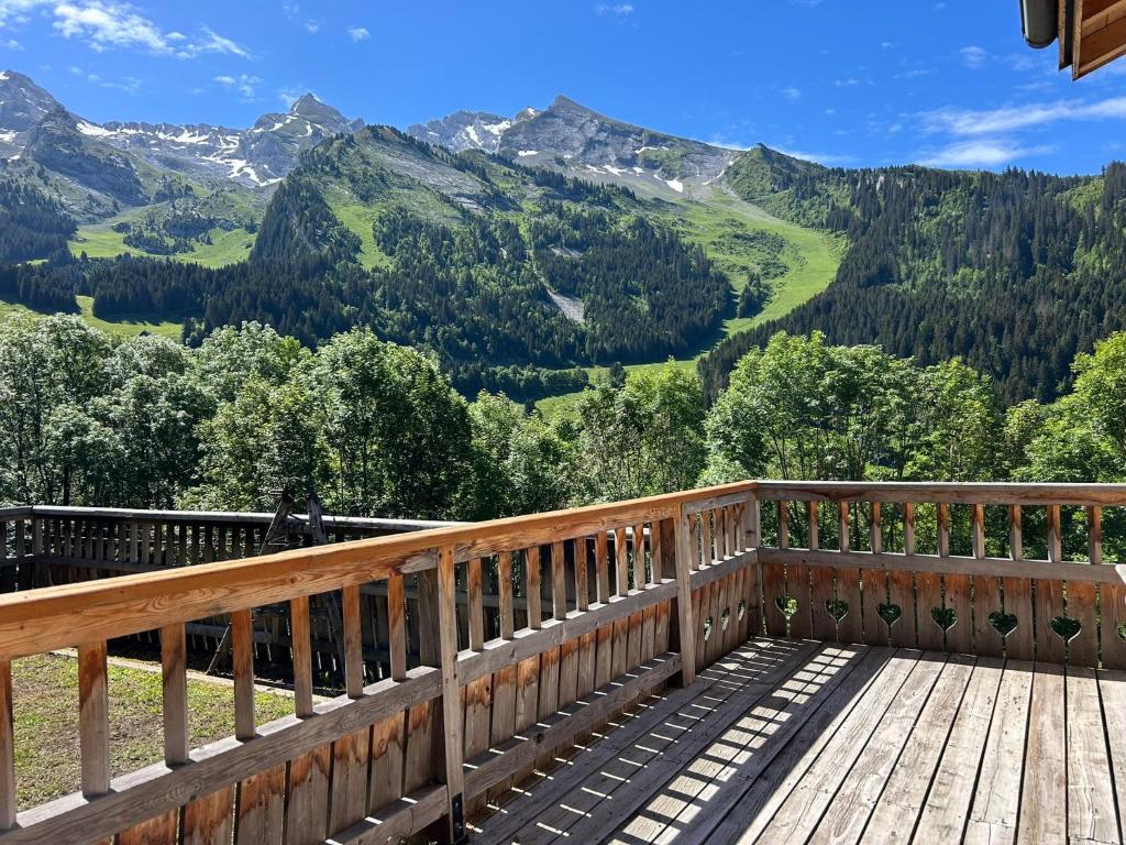 a wooden deck with a view of mountains at Chalet Savoyard in La Clusaz
