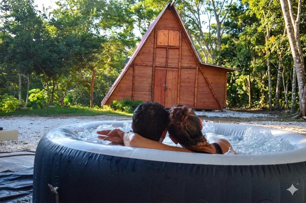 a man and a woman in a jacuzzi in a large tire at Alma Silvestre in Puerto Triunfo