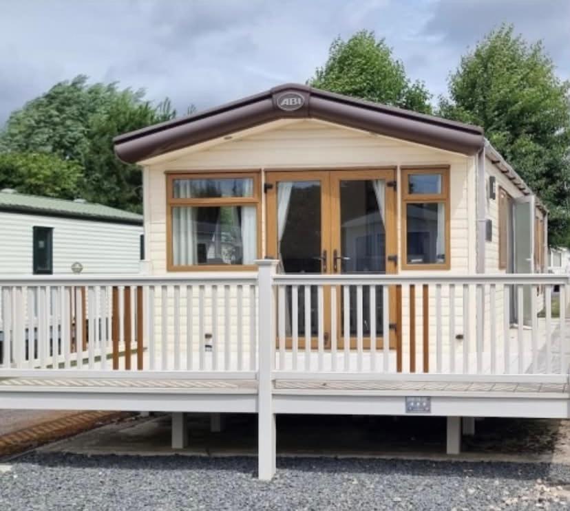 a tiny house with a white fence at Maisy's Retreat in Chapel Saint Leonards