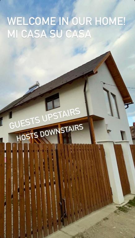 a white house with a fence in front of it at Mi casa su casa in Lăzarea