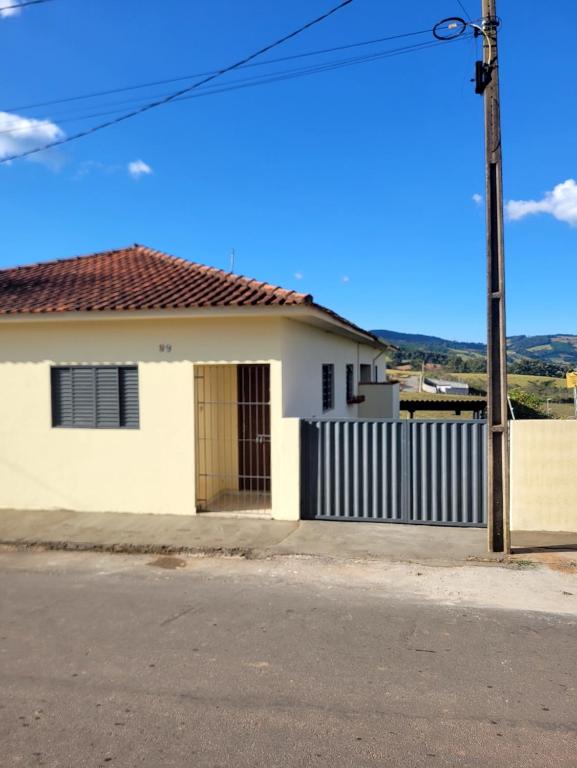a white house with a wooden door on a street at Pousada Welsh in Bueno Brandão