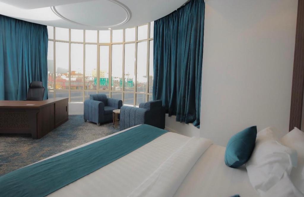 a hotel room with a bed and a large window at Areen Almatar Serviced Apartments شقق ارين المطار للشقق المخدومة in Jeddah