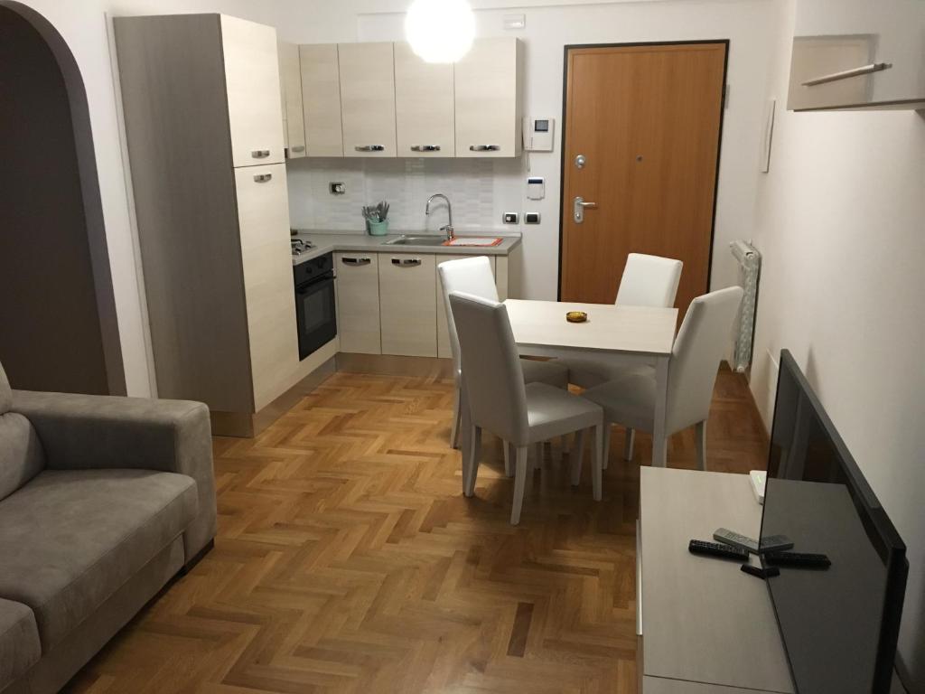 a kitchen and a living room with a table and chairs at Pianeta Roma 45 in Rome