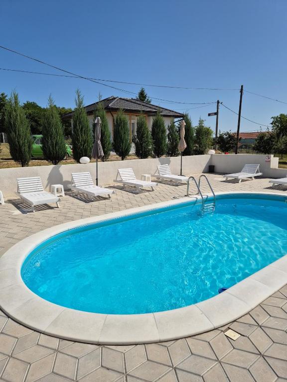 a swimming pool in a patio with lounge chairs at Pećinska Vila in Kragujevac