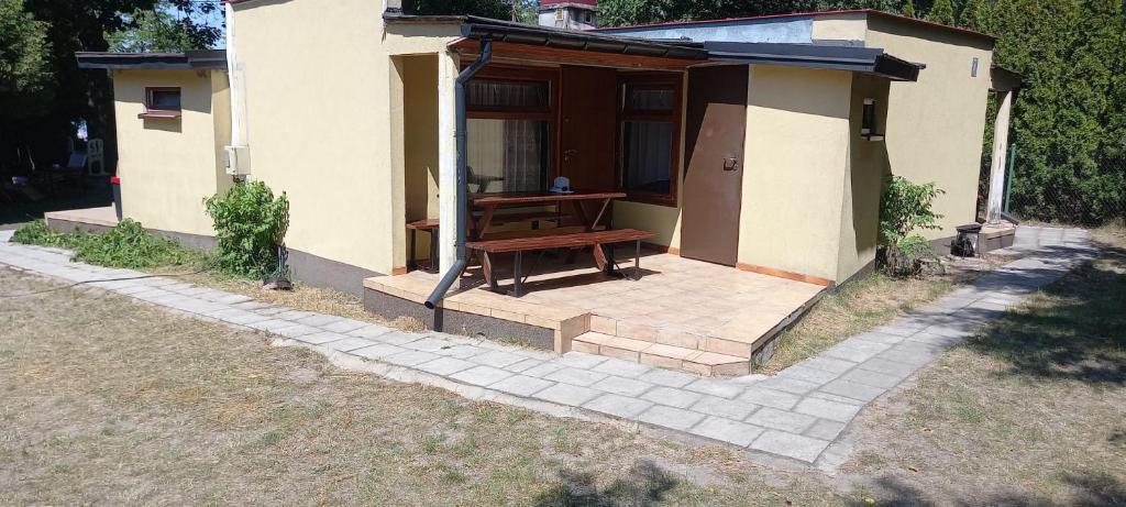 a small house with a bench on a patio at Domki u Ani in Białka