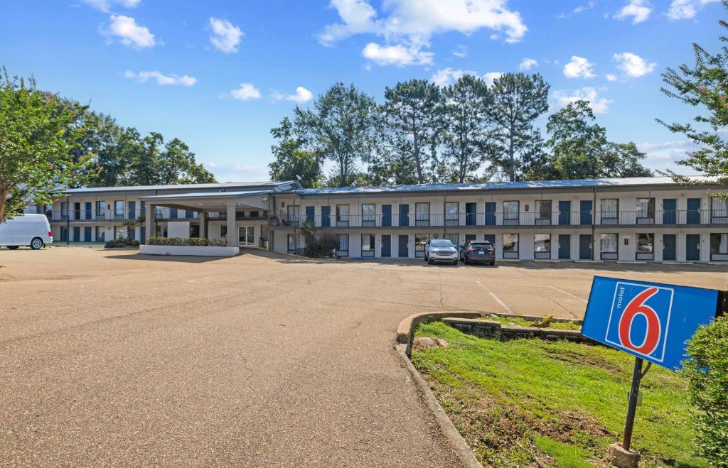 a building with a parking lot in front of it at Motel 6 - McComb, MS in McComb