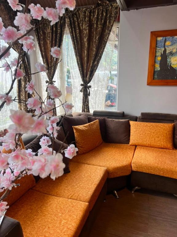 an orange couch in a living room with a tree at Anagrama house in Baños