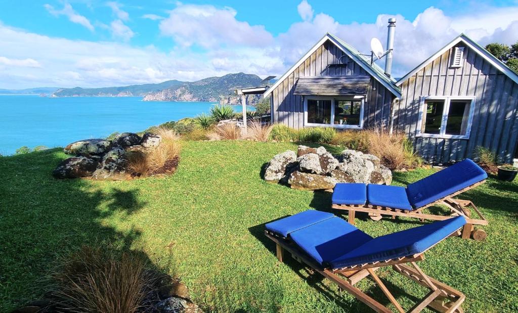a house with two lounge chairs in front of it at The Rock in Tuateawa