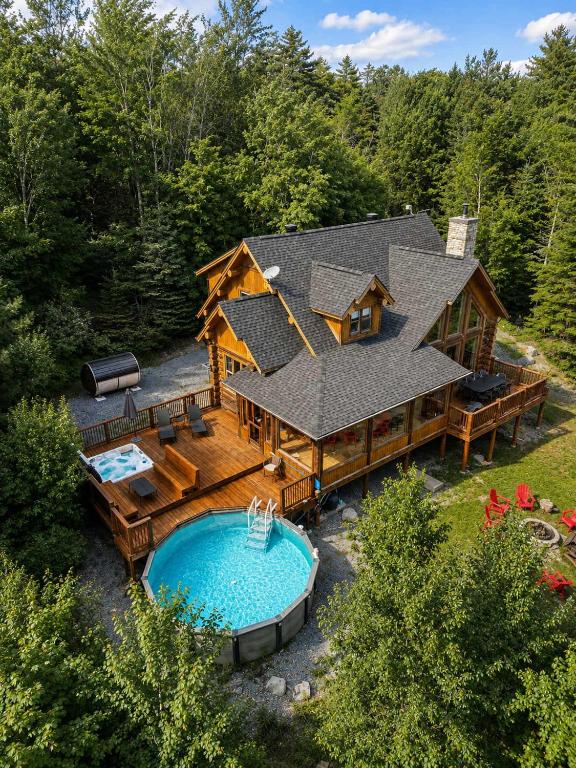 an aerial view of a log home with a pool at Blue Moose Private pool spa sauna lake access in Wentworth