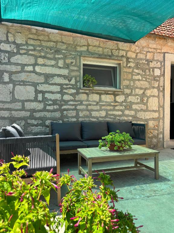 a patio with a couch and a table and some plants at Holiday house Misetic in Selca