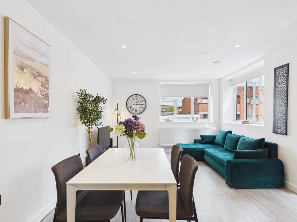 a living room with a table and a green couch at Luxury Two Bed | Sleeps 6 | 5 beds in Brent Station