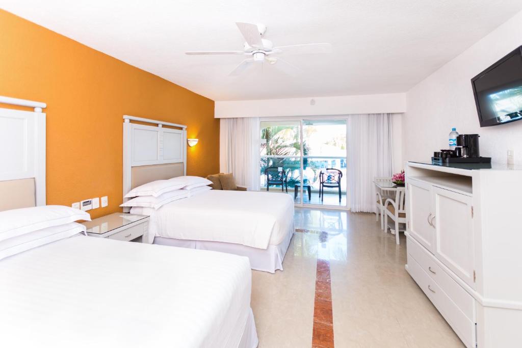 A bed or beds in a room at Occidental Costa Cancún - All Inclusive