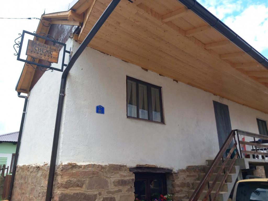 a building with a sign on the side of it at Smestaj kod Sneze in Dojkinci