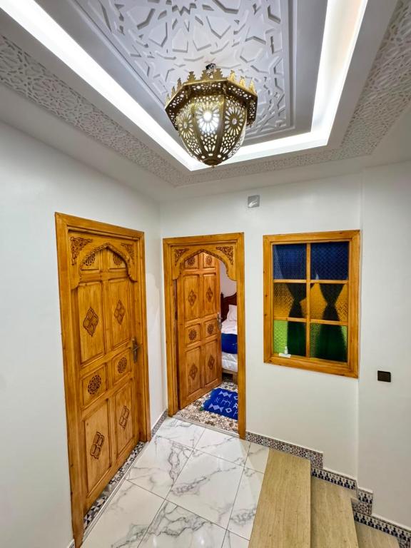 a room with wooden doors and a chandelier at FATI GUEST HOUSe in Chefchaouen