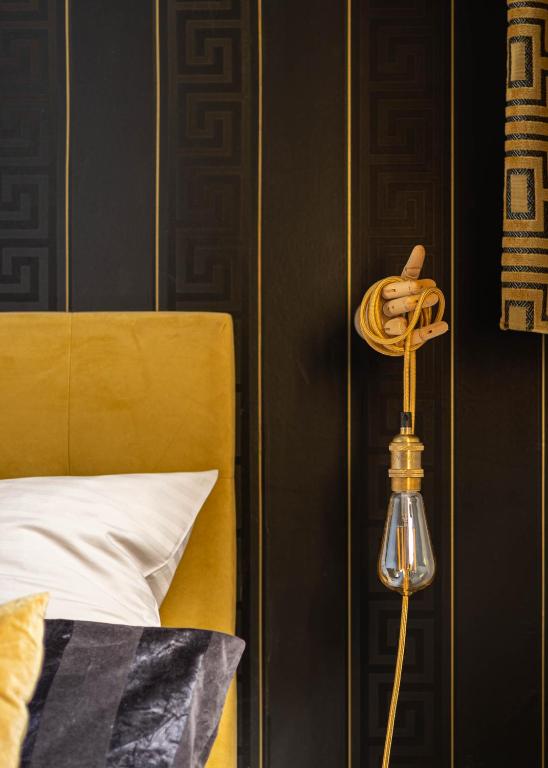 a lamp next to a bed in a bedroom at La Bulle Dorée in Épernay