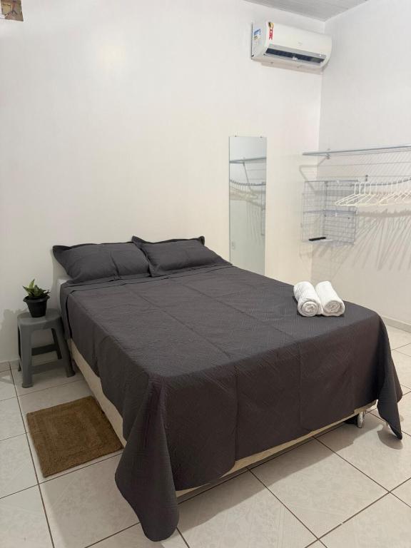 a bedroom with a large bed with a black blanket at Casa Fronteira in Oiapoque