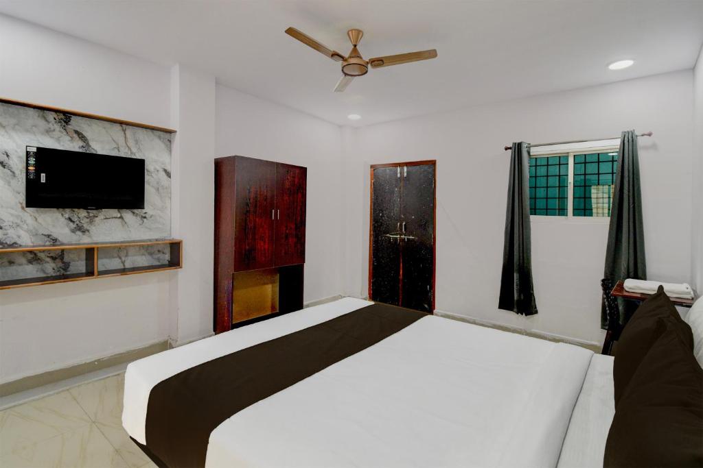 a bedroom with a bed and a ceiling fan at Super Hotel O iva Holiday inn in Maula Ali